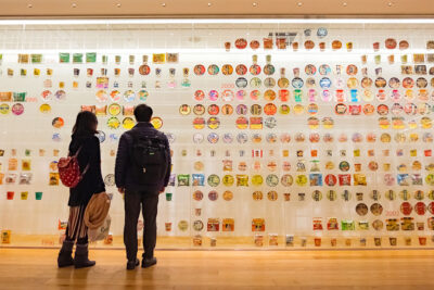 Two people looking at a wall of cup noodles at the Cup Noodles Museum in Yokohama