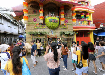 Tourists taking photos of one of the decorated houses at the Pahiyas Festival in 2023