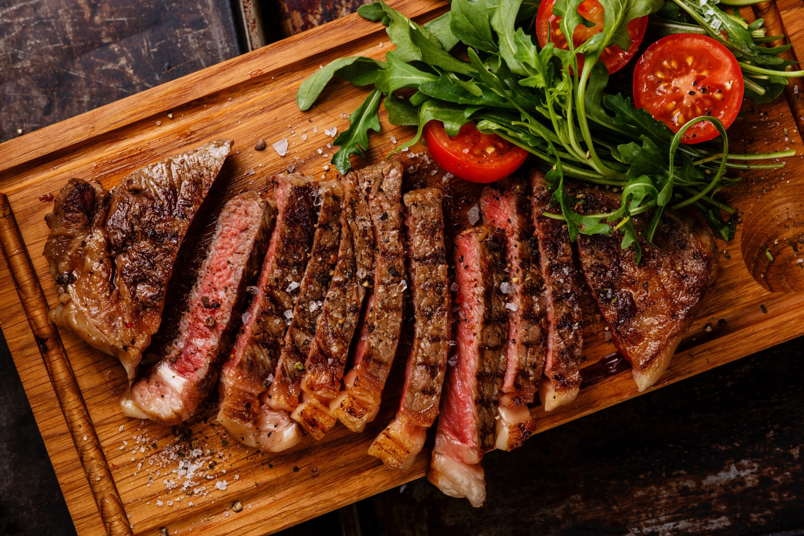 Steak cut up on a wooden board