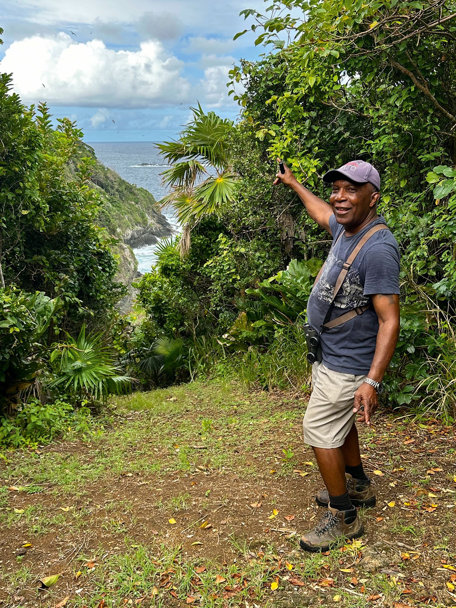 Man pointing towards the ocean down the hill