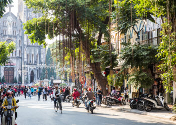 A crowd with busy traffic outside of St. Joseph Cathedral in Hanoi's Old Quarter