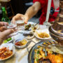 Two person toasting soju over food in South Korea