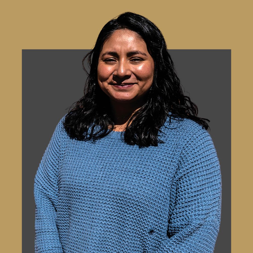 Women in a blue jumper smiling at he camera