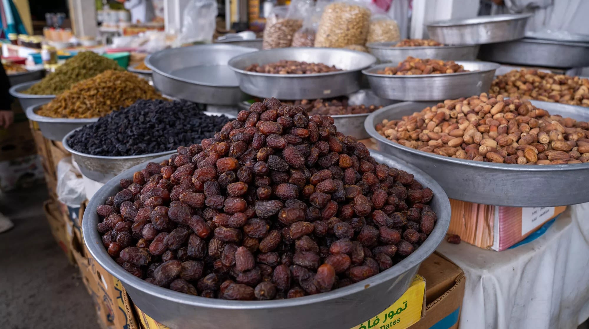 Dry fruits and nuts placed in big metal bowls on a vendor stall
