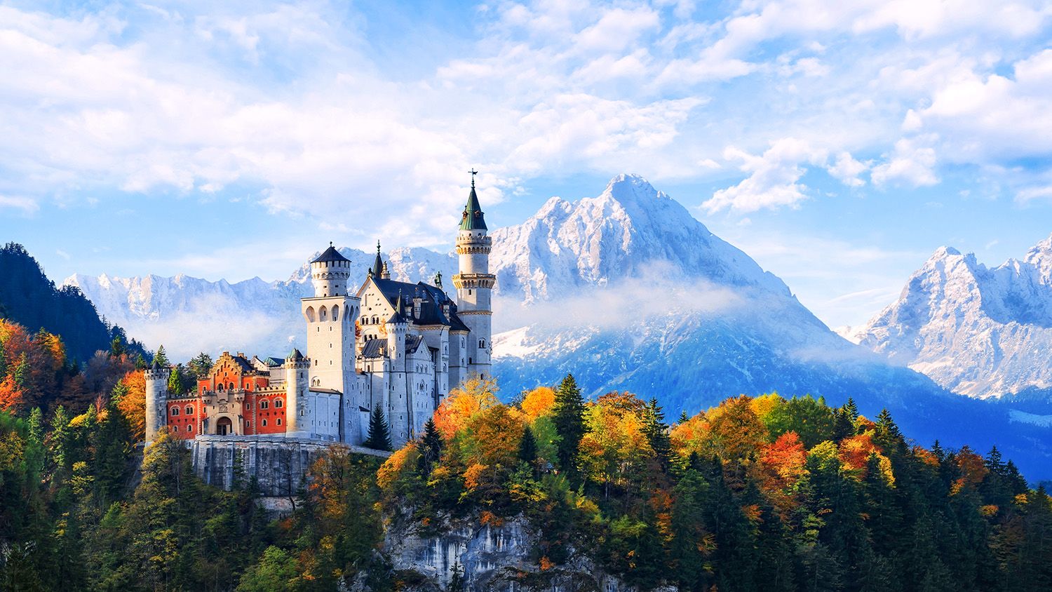 Castle surrounded by trees with mountain in background
