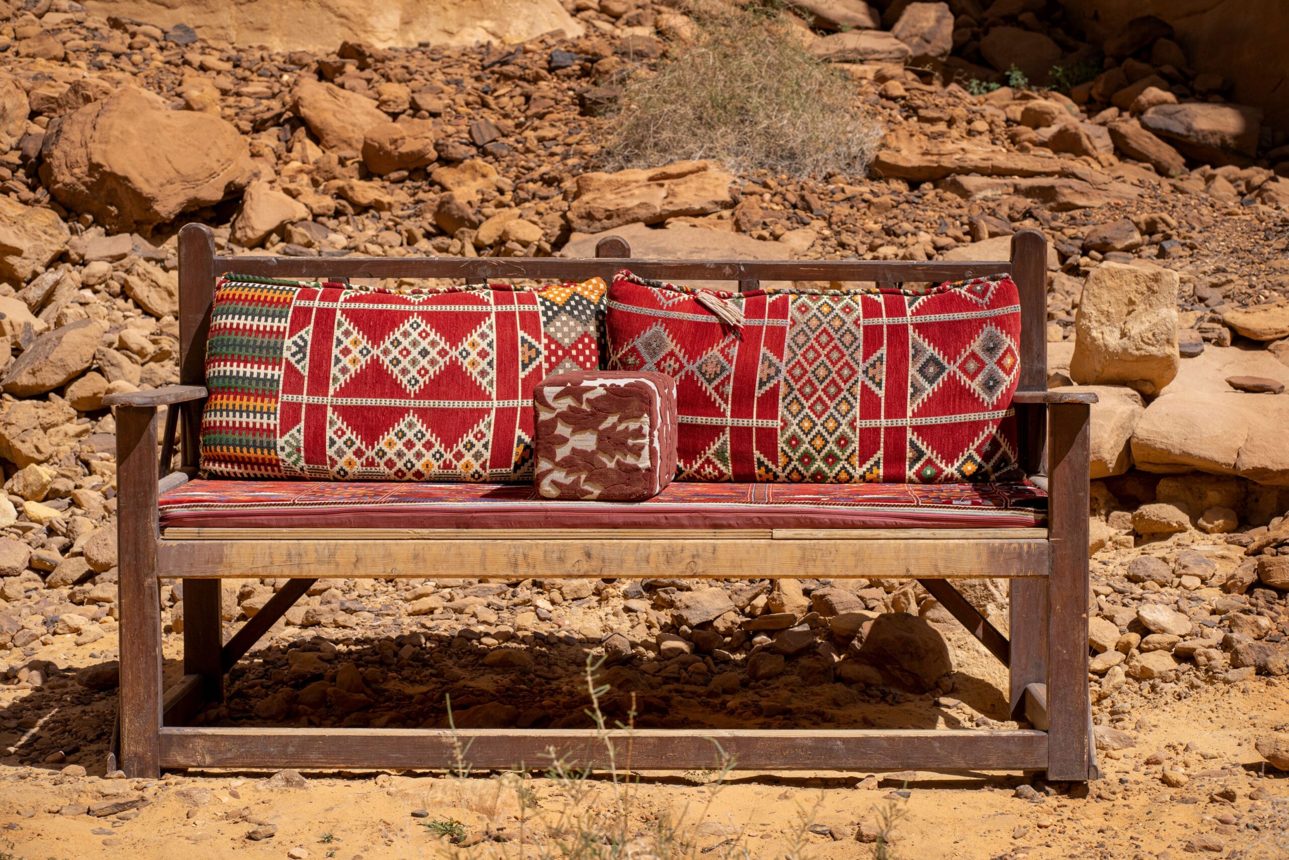 Wooden bench with red patterned cushions