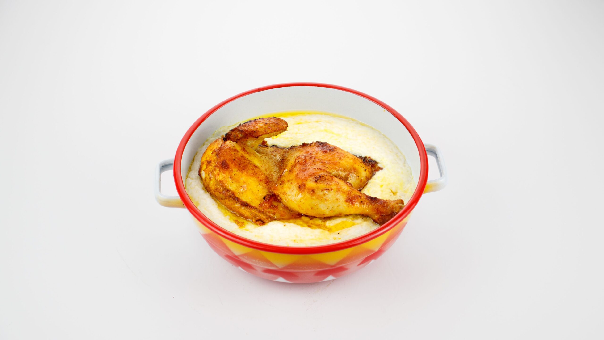 Chicken served on top of boiled puree rice in a bowl