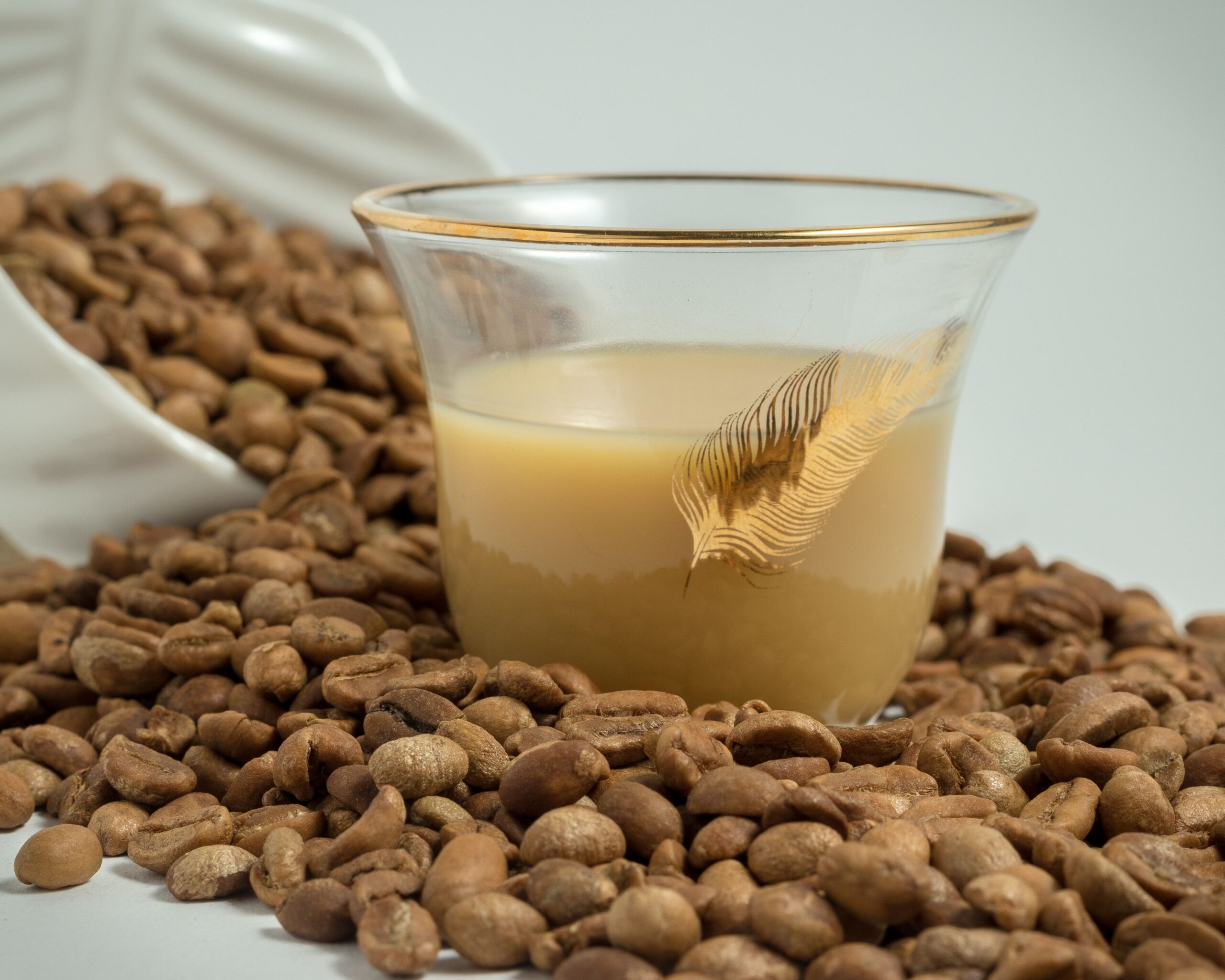 Coffee in a glass cup placed in between coffee beans
