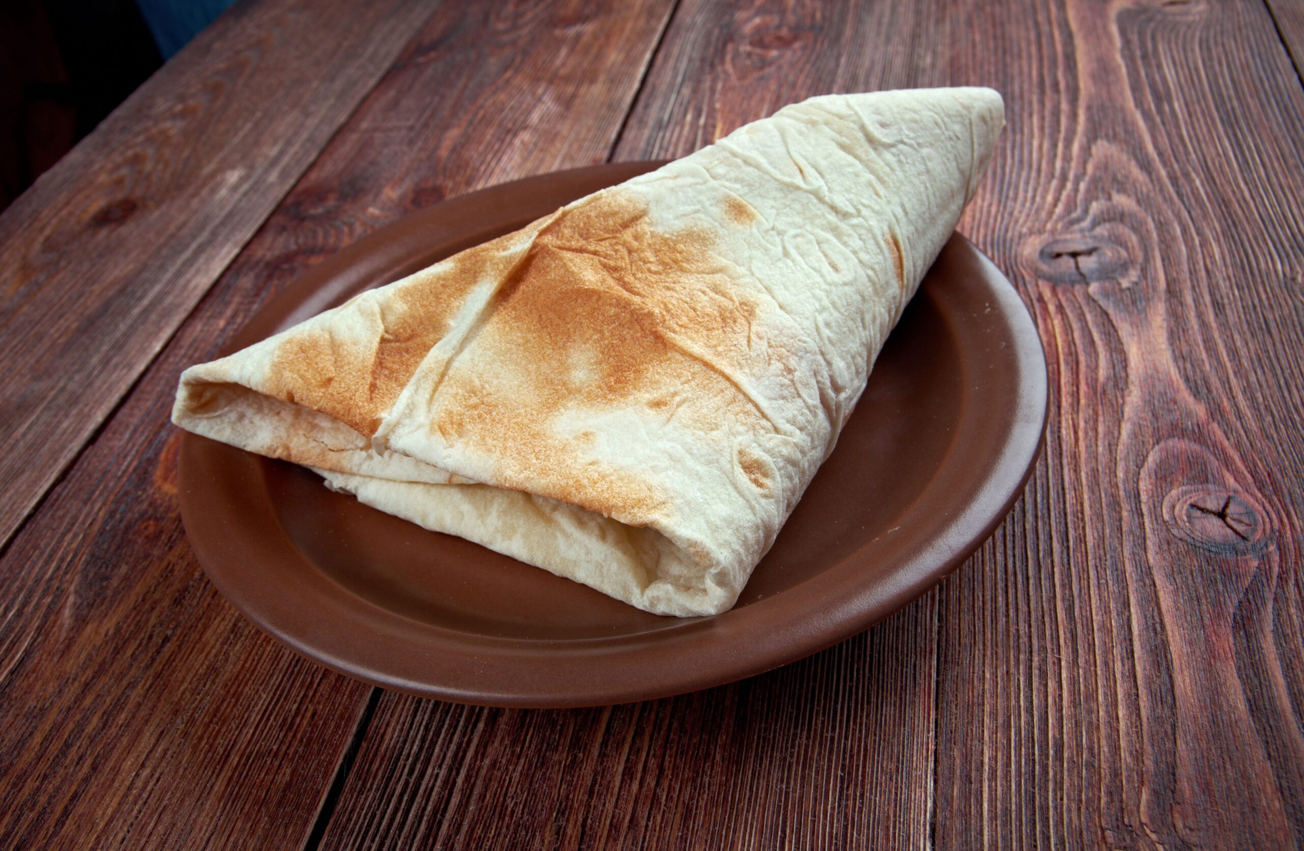 A wrap on a brown plate
