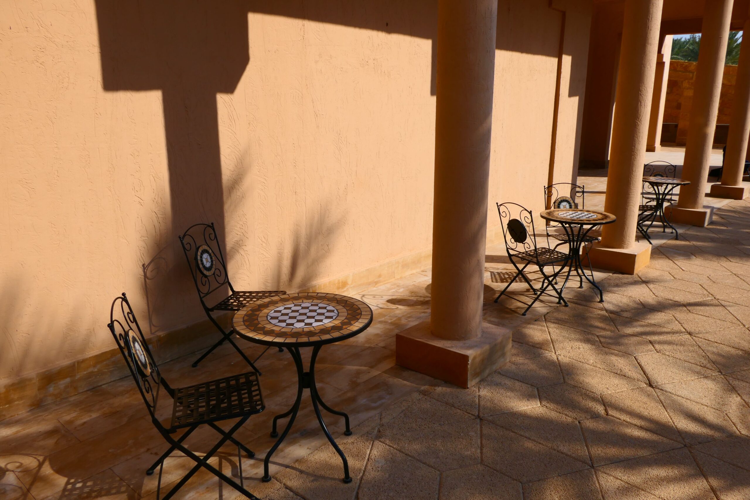 Deck chairs with tables placed outside between pillars