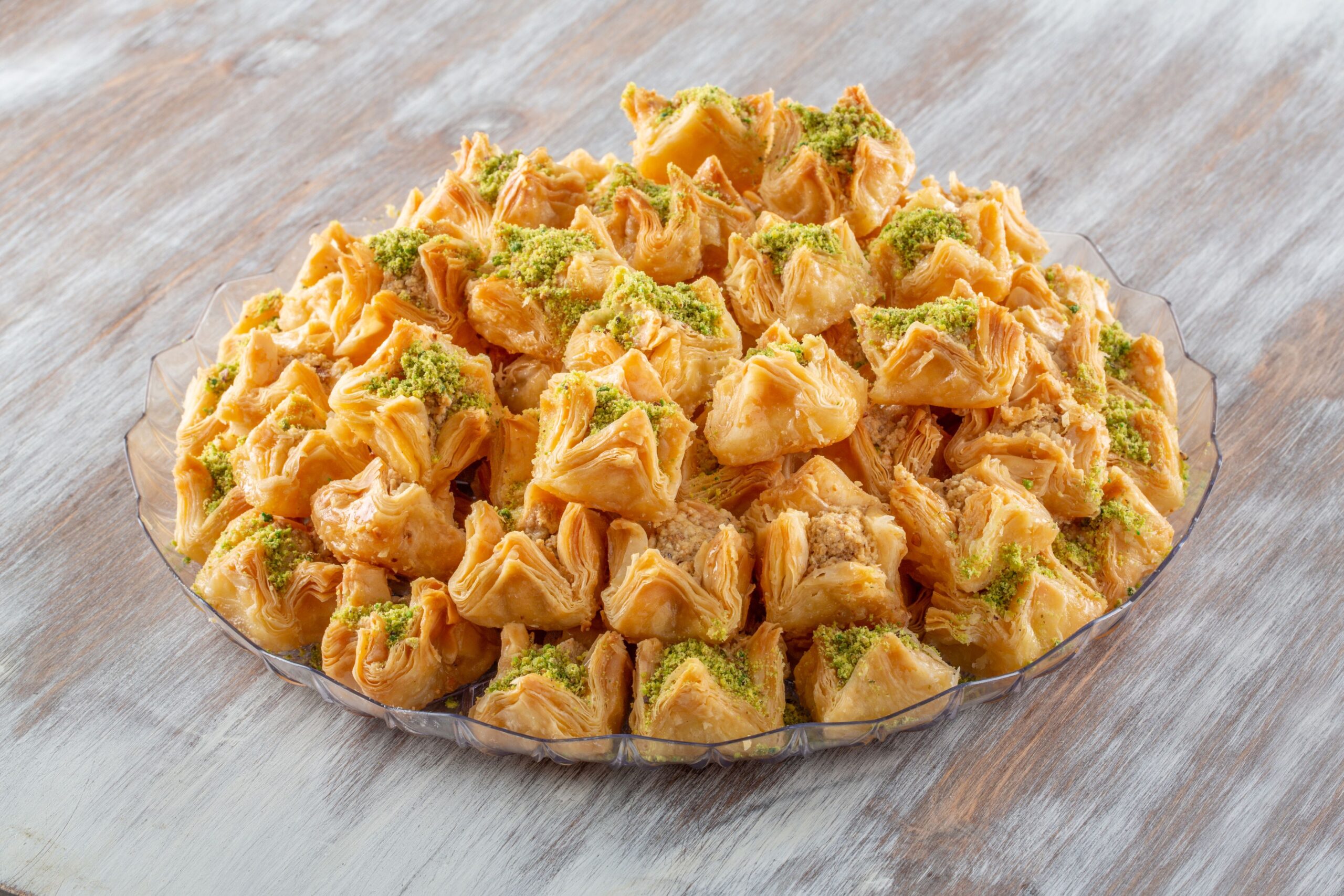 A pistachio dessert piled high on a clear glass plate