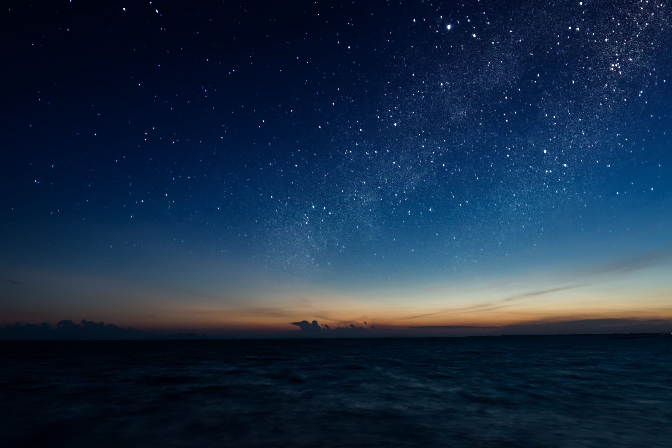 Sunset by the sea, the sky is covered in stars