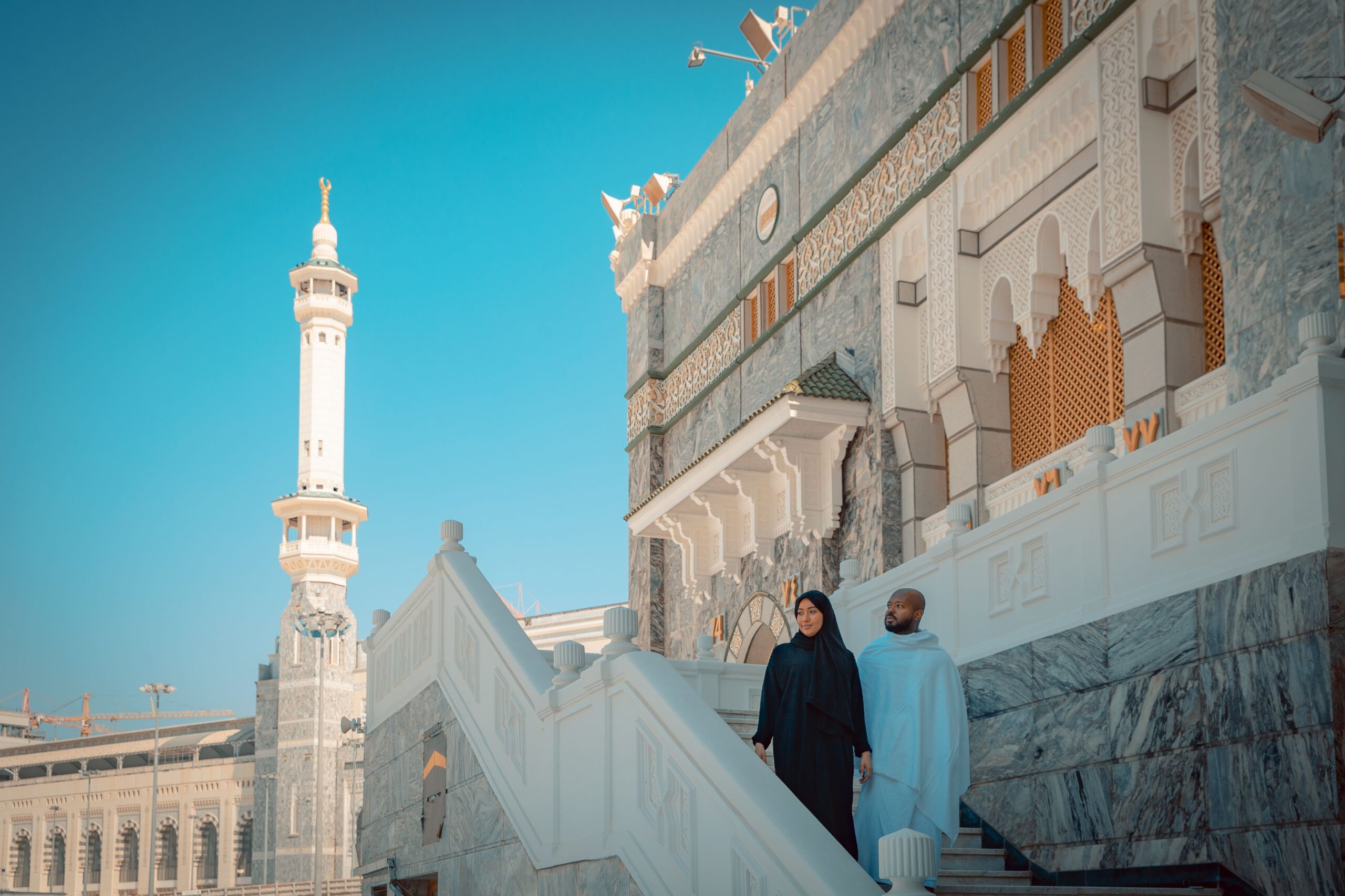 A couple walking down the stairs of the mosque